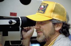 a man wearing a yellow hat and holding a camera