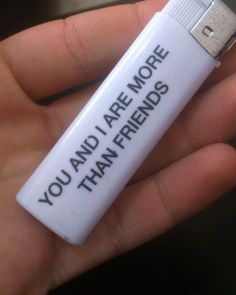 a hand holding a white usb stick with the words you and i are more than friends written on it