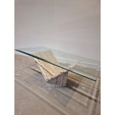 a glass and stone table on concrete in an empty room