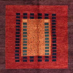 an orange, blue and black rug with squares on the center is in front of a white background