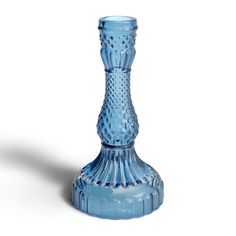 a blue glass vase sitting on top of a white table