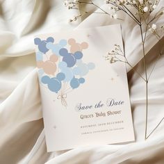 a wedding save the date card on top of a bed with flowers and baby's breath