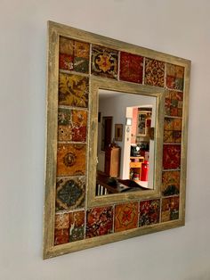 the mexican tile mirror is hanging on the wall