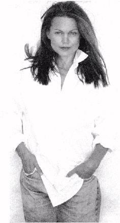 an old black and white photo of a woman with long hair wearing a button up shirt