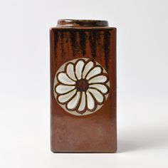 a brown and white vase sitting on top of a table