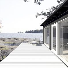 a house on the shore with water in the background