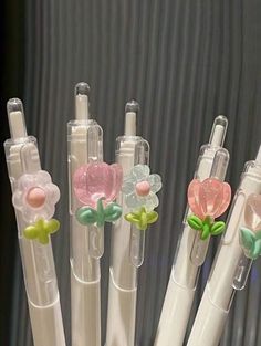 four pens with flower decorations on them are lined up in a row and ready to be filled