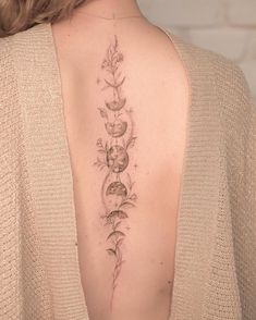 the back of a woman's shoulder with flowers and skulls tattooed on her upper arm