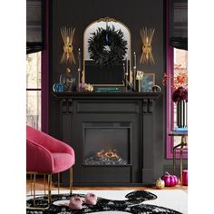 a living room decorated in black and gold with pink chairs, rugs and a fireplace