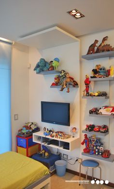 a bedroom with shelves and toys on the wall