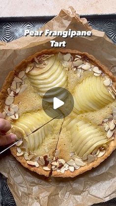 a person is cutting into a pie with almonds and other toppings on it