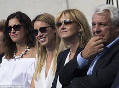 several people are sitting next to each other in the stands at a tennis match, all wearing sunglasses