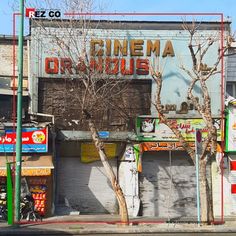 an old building with some signs on the side of it and trees in front of it