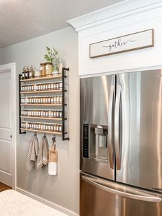 a stainless steel refrigerator with spice rack above it