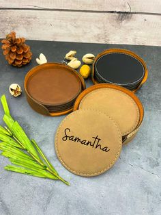 three round leather coasters with the word samantana written on them