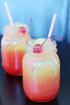 two mason jars filled with drinks sitting on top of a table