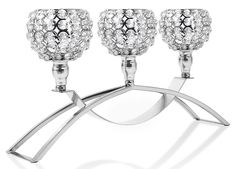 three crystal candlesticks are sitting on a metal stand with two holders in the middle