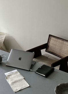 an open laptop computer sitting on top of a table next to a vase with flowers