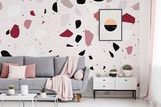 a living room with pink and black paint on the walls, a grey couch and a white coffee table