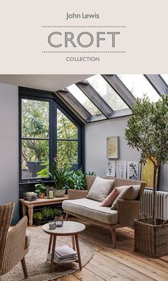 a living room filled with lots of furniture next to a large window covered in plants