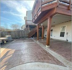 an outdoor patio with steps leading up to the back door and stairs going up to the second floor