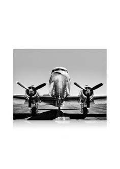 an airplane is parked on the tarmac in black and white with its propellers down