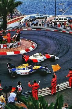 two racing cars on a race track with people watching