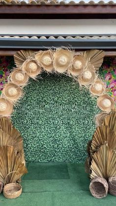 two straw hats are on display in front of a green backdrop with flowers and leaves