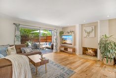 a living room filled with furniture and a flat screen tv mounted to a wall next to a fire place