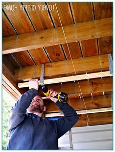 a man holding a pair of scissors while working on a wood ceiling with the words lovely craft home above him