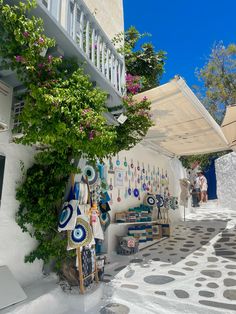 an alleyway with art on the walls and potted plants growing up to it