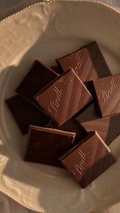 some chocolates are sitting on a white plate