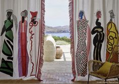 an open door with colorful curtains and artwork on it