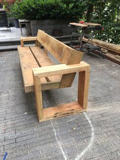 a wooden bench sitting on top of a sidewalk