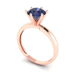 a rose gold engagement ring with a blue sapphire stone in the center, on a white background