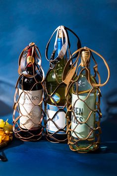 three bottles of wine sitting next to each other on top of a blue tablecloth