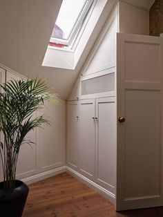 an empty room with white cabinets and a potted plant