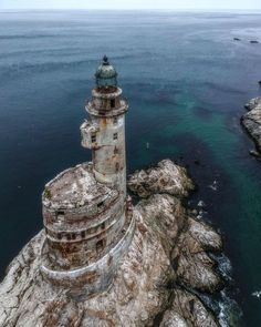 an aerial view of a light house on top of a cliff