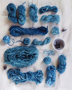 several skeins of blue yarn are laid out on a sheet