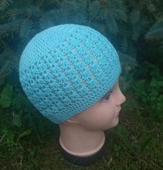 a blue crocheted hat on top of a mannequin's head