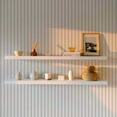 two white shelves filled with vases and other items