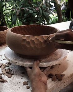 a person is working on a pottery bowl