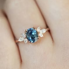 a woman's hand with a blue and white diamond ring