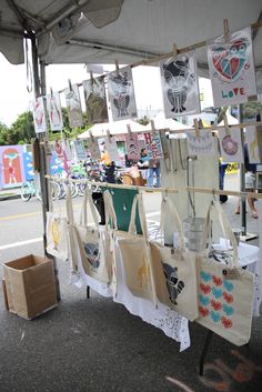 an outdoor market with many bags hanging from the ceiling