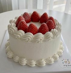 a cake with white frosting and strawberries on top