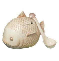 a ceramic fish with a spoon in it's mouth