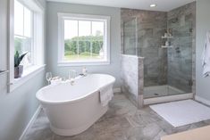 a white bath tub sitting next to a walk in shower