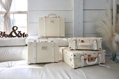 four pieces of luggage sitting on top of a white couch