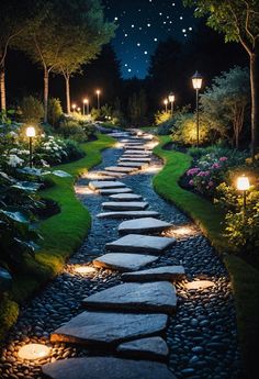 a pathway lit up with lights in the middle of a park at night, surrounded by flowers and trees