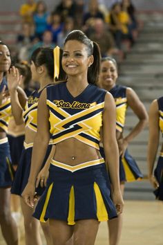 the cheerleaders are all dressed in blue and yellow outfits, with one girl smiling at the camera